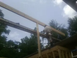 Carpenter setting a ridge beam over a new addition frame — Ice Dam Removal by Roofing Brothers in Winona Lake