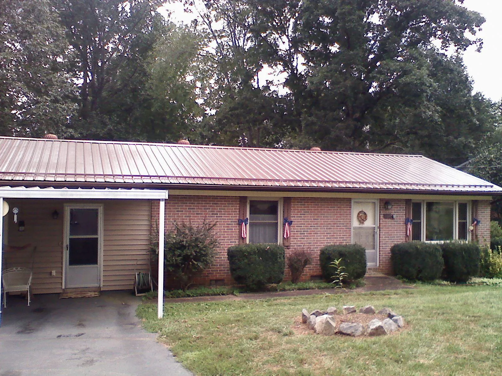 Bronze metal roof and carport on a brick ranch home — Roof Repair work by our crew in Winona Lake